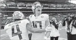  ?? ELAINE THOMPSON/AP ?? QB Justin Herbert and WR Mycah Pittman celebrate after No. 12 Oregon’s win Saturday.