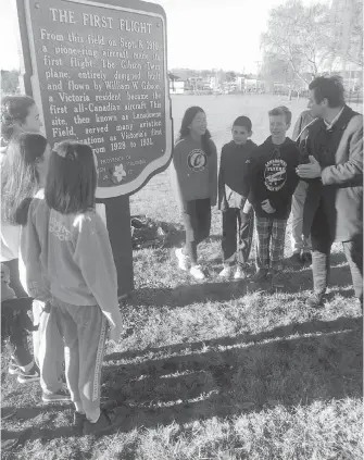  ??  ?? Victoria-Swan Lake MLA and Education Minister Rob Fleming, right, with students on the large playing field at Lansdowne Middle School, once the site of Victoria’s first airport from 1928 to 1931. The students unveiled a government sign on Wednesday...