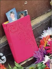  ??  ?? Photos of a young Logan Turner peek from a pink-covered Bible that remains part of the memorial outside Ned Peppers in the Oregon District.