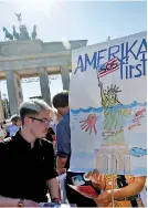  ??  ?? People hold banners as they protest against the US withdrawal from the Paris climate change deal, in Berlin, Germany, June 2, 2017. REUTERS/ Fabrizio Bensch