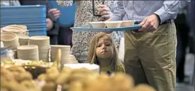  ?? Antonella Crescimben­i/Post-Gazette ?? Maryn Kugler, 3, of Jefferson Hills, waits in the soup line with her parents at the annual Empty Bowls Dinner benefiting Greater Pittsburgh Community Food Bank on Sunday, March 18, 2018.