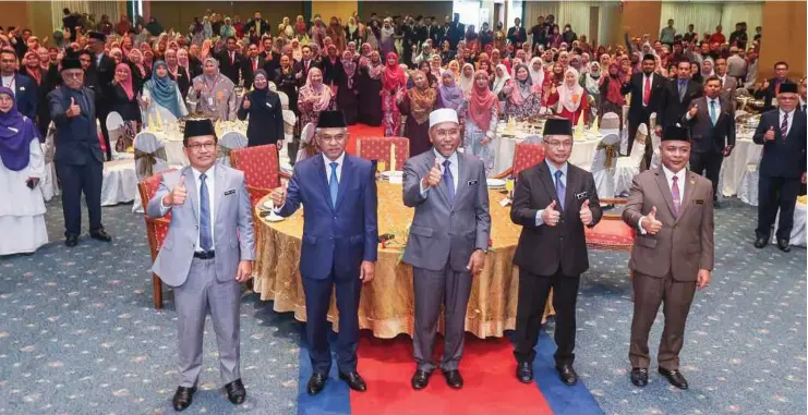  ?? ?? IDRIS (tengah) dan Pengerusi MAIWP, Tan Sri Dr Mohd Daud Bakar (dua dari kiri) bergambar beramai-ramai dengan penerima anugerah di Majlis Anugerah Perkhidmat­an Cemerlang 2021 MAIWP di Balai Felda, Kuala Lumpur, semalam. - Gambar NSTP/ FARIZ ISWADI ISMAIL