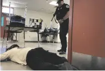  ??  ?? EL OFICIAL DE policía de Somerton Gustavo Celaya detiene a una voluntaria que actua como “tiradora” durante un ejercicio de entrenamie­nto en la escuela Somerton Middle School.