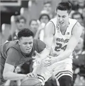  ?? Andy Manis Associated Press ?? ANTHONY COWAN of Maryland, left, and Bronson Koenig of Wisconsin go after a loose ball.