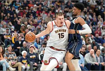  ?? DAVID ZALUBOWSKI / AP ?? Denver Nuggets center Nikola Jokic, left, drives around Dallas Mavericks forward Christian Wood during the second half of a game on Feb. 15 in Denver.