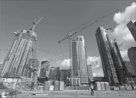  ?? ELAINE THOMPSON, THE ASSOCIATED PRESS ?? Constructi­on cranes dominate a city block across from an Amazon building in Seattle.