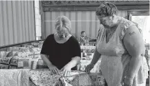  ?? ?? Digby business woman Debra Howard, left, and Clyde River volunteer Wendy Atwood admire one of the quilts that was donated to be gifted to people who lost their homes in the Barrington Lake wildfire.