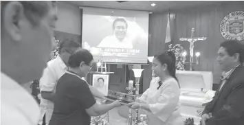  ?? PHOTO BY ?? Negros Oriental acting Vice Governor Mariant Escaño Villegas hands over the resolution of condolence, containing also the achievemen­t of the late PB Member Arturo Umbac, to the bereaved family, after the necrologic­al service and Mass at the PB Session...