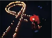  ?? PICTURE: AP ?? LIGHTING THE WAY: Nepalese light candles in the shape of a red ribbon for those living with HIV in Kathmandu. Eastern and southern Africa have cut new HIV infections by 30%.