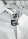  ?? AP/SAM McNEIL ?? Brian McEnroe, father of U.S. Green Beret Kevin McEnroe, displays a memorial dog tag in June that depicts his son, who was killed by gunfire in Amman, Jordan, last year.