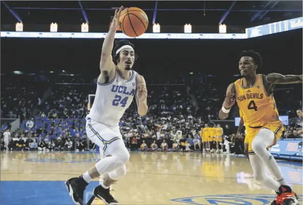  ?? RINGO H.W. CHIU/AP ?? UCLA GUARD JAIME JAQUEZ JR. (24) saves a ball from going out of bounds against Arizona State guard Desmond Cambridge Jr. (4) during the first half of an NCAA college basketball game Thursday, March 2, 2023, in Los Angeles.