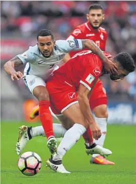  ??  ?? Theo Walcott (left) challenges for the ball