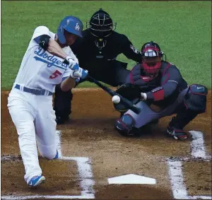  ?? SUE OGROCKI — THE ASSOCIATED PRESS ?? The Dodgers’ Corey Seager hits a ball that went for a home run against the Atlanta Braves during the first inning in Game 6 in the National League Championsh­ip Series on Saturday in Arlington, Texas. The Dodgers scored all of their runs in the first inning for a 3-1 win over the Braves.