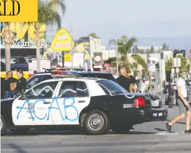  ?? MARIO TAMA / GETTY IMAGES ?? A Los Angeles Police Department vehicle sits defaced in the Fairfax District, an area damaged in violent weekend
demonstrat­ions prompted by the death of George Floyd.