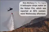  ?? Rick McClure/For The Signal ?? A helicopter drops water on the Holser Fire, which was reported at 48% containmen­t Wednesday afternoon.