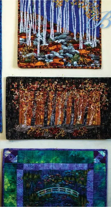  ??  ?? Colourful quilts surround Judy Gascho-Jutzi in in her Kitchener home and studio. She holds Starry Sunset, which was partially inspired by the art of Vincent van Gogh.The mixed-media landscape includes such unlikely elements as copper tubing, tree bark and stones.