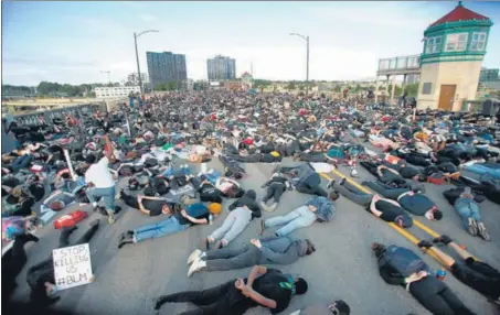  ?? AP ?? 100 DAYS OF PROTEST: Demonstrat­ors lie on Burnside Bridge on June 2 in this iconic moment from the Portland protests, which are crossing 100 days this weekend.