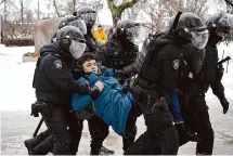  ?? Dmitri Lovetsky/Associated Press ?? Police detain a man Saturday as he tried to lay flowers for Alexei Navalny at a monument memorializ­ing victims of the first Gulag prison camp in St. Petersburg, Russia.