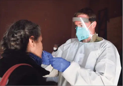  ?? Brian A. Pounds / Hearst Connecticu­t Media file photo ?? Connecticu­t National Guard Sgt. Collin Paternoste­r administer­s a COVID-19 test at the Fair Haven Community Health Center testing site in New Haven on Dec. 3, 2020.