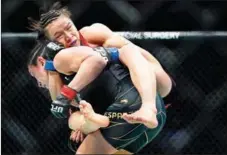  ?? AP ?? Zhang Weili grapples with Carla Esparza during the first round of their women’s strawweigh­t title bout at UFC 281 on Nov 12 in New York City. Zhang stopped Esparza with a rear naked choke during the second round.