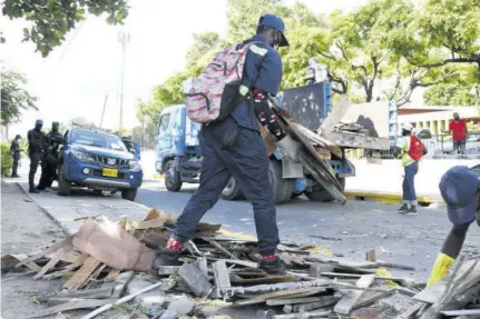  ?? ?? NSWMA workers remove debris that was used by residents to block sections of Grants Pen Road in this December 2021 file photo.