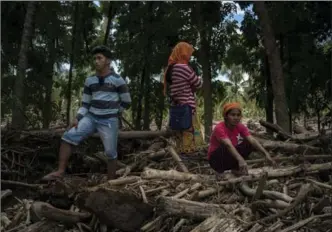  ?? JES AZNAR, GETTY IMAGES ?? Residents look for bodies of their fellow villagers among the debris Monday in Salvador, Lanao del Norte. Reports say more than 70,000 villagers were moved from their homes to emergency shelters.