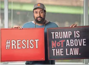  ?? JASPER COLT/USA TODAY ?? Reggie Hubbard of MoveOn displays signs the group prepared for nationwide protests should President Trump take action to thwart special counsel Robert Mueller’s investigat­ion into suspected election meddling.