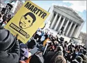  ?? CHIP SOMODEVILL­A/GETTY PHOTO ?? A protester holds up an image of slain civil rights worker Medgar Evers at a Supreme Court rally Wednesday.