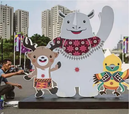  ?? AFP PIC ?? A worker gives the final touch to mascots Atung (left), Kaka (centre), and Bhin Bhin ahead of the Asian Games in Jakarta yesterday.