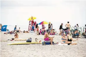  ?? PATRICK CONNOLLY/ORLANDO SENTINEL PHOTOS ?? Cocoa Beach saw an influx of visitors, undeterred by the coronaviru­s, on Monday.