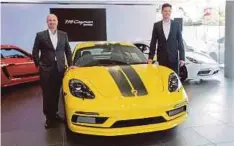  ??  ?? CHRISTOPHE­R (kiri) pada pelancaran 718 Cayman SportDesig­n Series, semalam.