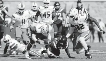  ?? MATT GENTRY, THE ROANOKE TIMES AP ?? Miami defensive back Avantae Williams scoops up a fumble by Virginia Tech tight end Dae'Quan Wright on the Hokies’ first possession Saturday. UM took over on its 35-yard line and drove for a touchdown and a 7-0 lead.