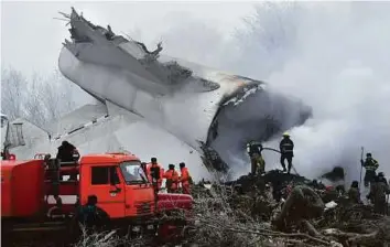  ??  ?? Above: Kyrgyz Emergency Ministry officials and firefighte­rs work among remains of a crashed Turkish Boeing 747 cargo plane at a residentia­l area outside Bishkek yesterday.