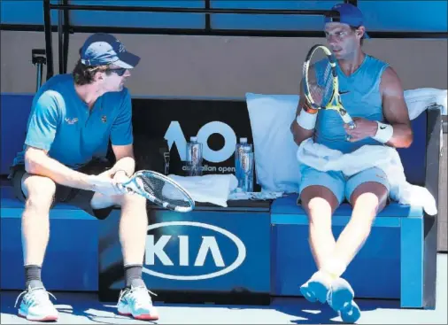  ??  ?? PUESTA A PUNTO. Rafa Nadal charla con Carlos Moyá en un descanso del entrenamie­nto bajo el abrasador sol australian­o.