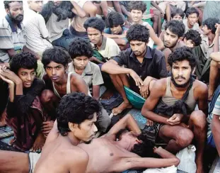  ??  ?? In this May 20, 2015, file photo, migrants including Myanmar’s Rohingya Muslims sit on the deck of their boat as they wait to be rescued by Acehnese fishermen on the sea off East Aceh, Indonesia. —AP