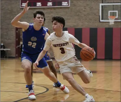  ?? PAUL DICICCO — FOR THE NEWS-HERALD ?? University’s Faris Dahman drives against Gilmour’s Ben Demell on Feb. 13.