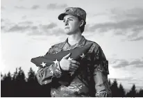  ?? Associated Press ?? n On Monday, Capt. Jennifer Peace holds a flag as she stands for a photo near her home in Spanaway, Wash.