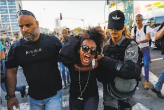  ?? Ahmad Gharabli / AFP / Getty Images ?? Israeli security forces detain a protester during a demonstrat­ion in Tel Aviv against police violence and the recent killing of a young EthiopianI­sraeli teenager in Haifa.