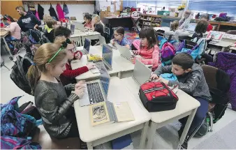  ?? TYLER BROWNBRIDG­E ?? A Grade 3 class work on a programmin­g lesson at St. Rose Catholic Elementary School in Windsor. The provincial government announced Wednesday overall class sizes will be reduced beginning this fall.