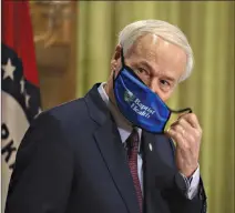  ?? (Arkansas Democrat-Gazette/Staton Breidentha­l) ?? Gov. Asa Hutchinson removes a mask before speaking Thursday July 16 at the state Capitol in Little Rock during his daily COVID19 briefing, where he announced a statewide mask order.