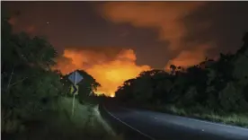  ??  ?? Volcanic activity from the Malama Ki and Leilani Estates neighborho­ods glows in the distance from Hwy 137, Thursday, May 17 near Pahoa, Hawaii. AP PHOTO/MARCO GARCIA