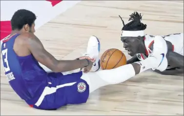  ??  ?? Paul George y Wenyen Gabriel pelean por un balón en el Blazers-Clippers de ayer.