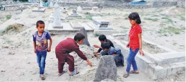  ?? Reuters ?? ↑
Children put flowers over the grave of Fatima Khalil, who was killed in a bomb blast on Saturday in Kabul, on Tuesday.