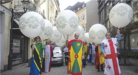  ?? — AP ?? BADEN-BADEN, Germany: Twenty activists dressed in national flags of poor countries demonstrat­e with balloons against the critical indebtedne­ss of 116 states worldwide during the G20 finance ministers’ meeting yesterday.