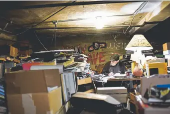  ?? Photos by AAron Ontiveroz, The Denver Post ?? Owner Duane Davis works among boxes of unshelved inventory in his basement office.