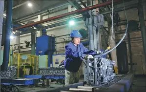  ??  ?? A technician at Weichai works on an engine block production line at the company’s factory in the high-tech zone.