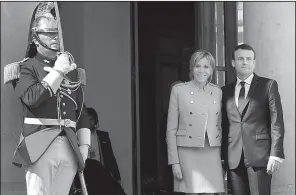  ?? AP/CHRISTOPHE ENA ?? New French President Emmanuel Macron and his wife, Brigitte, pose for photograph­ers Sunday at Elysee Palace in Paris after the hand-over ceremony with former President Francois Hollande.