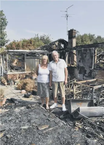  ??  ?? Dave and Olwyn survey the damage to their home