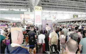  ?? — AFP ?? Stranded passengers wait at the check-in area at the Suvarnabhu­mi Internatio­nal Airport in Bangkok on Thursday.