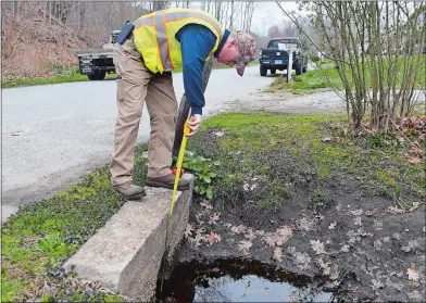  ?? SARAH GORDON THE DAY ?? Jim Corley, Preston public works manager, measures cross culverts along Lynn Road on Thursday so he can purchase materials for a repair project. He is the first person to hold the town’s new position.
